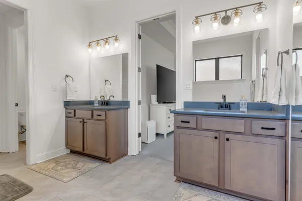 a spacious bathroom with a double vanity sink and mirror