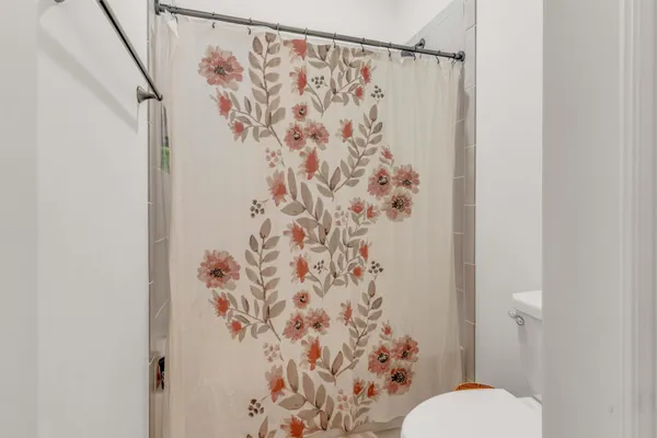 a white toilet sitting next to a shower curtain