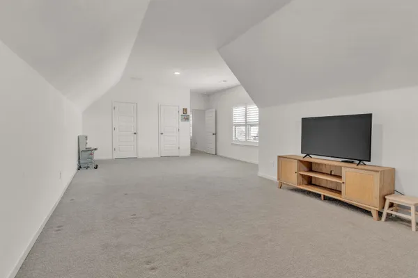 an empty room with furniture and flat screen tv