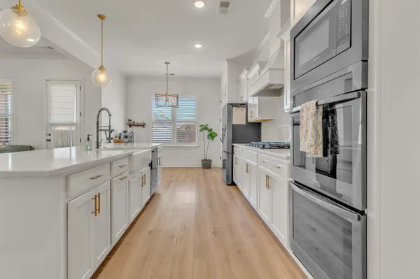 a large white kitchen with stainless steel appliances
