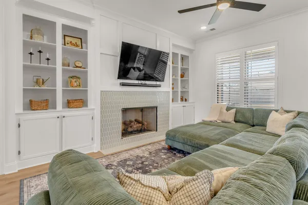 a living room with a bed a flat screen tv and a fireplace