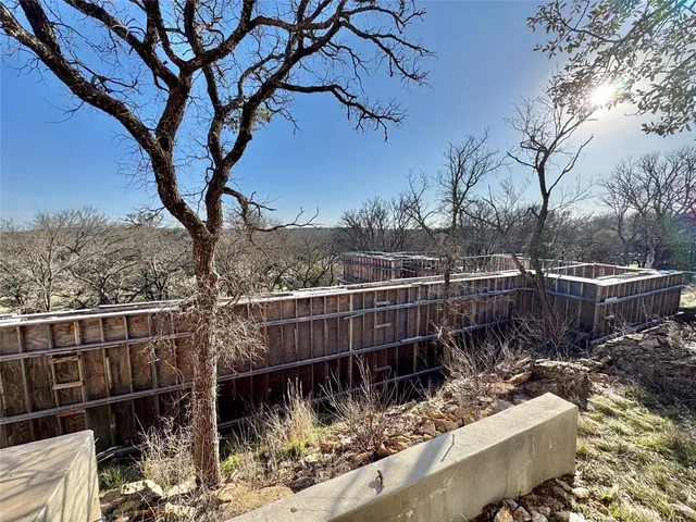 a view of a roof deck with wooden fence and large trees