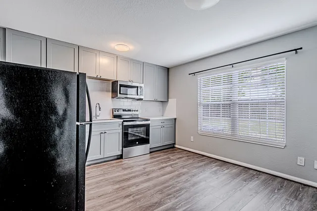 a kitchen with granite countertop a refrigerator stove and oven