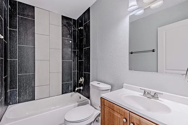 a bathroom with a sink toilet vanity and shower
