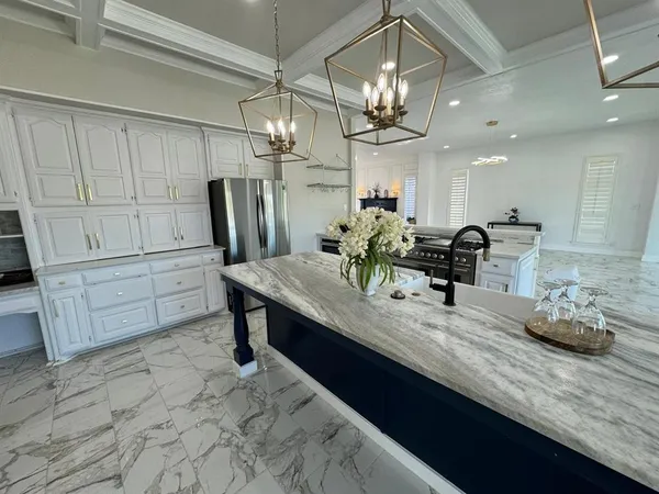 a kitchen with granite countertop a table chairs in it and wooden floors