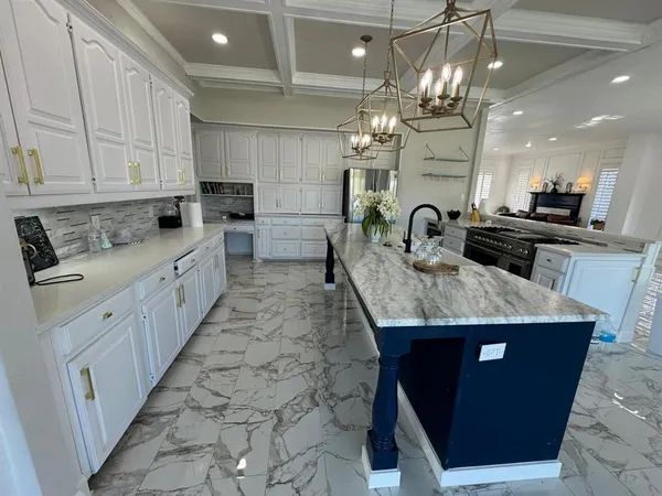 a kitchen with kitchen island granite countertop a counter space a sink appliances and cabinets
