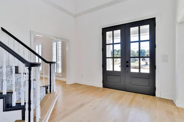a view of empty room with wooden floor and stairs