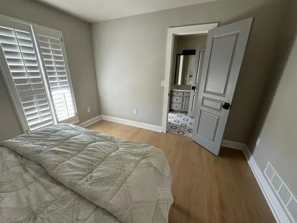 a bed sitting in a bedroom next to a window