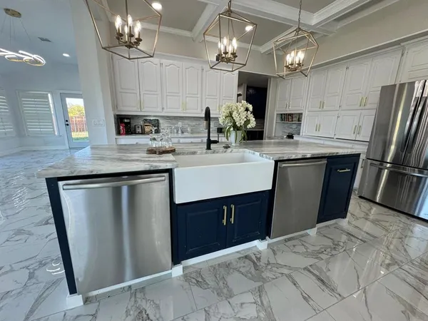 a kitchen with stainless steel appliances granite countertop a sink a stove a refrigerator and cabinets