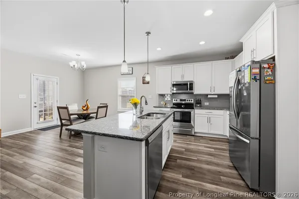 a kitchen with counter top space a sink appliances and cabinets