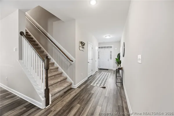 a view of a hallway with wooden floor and staircase