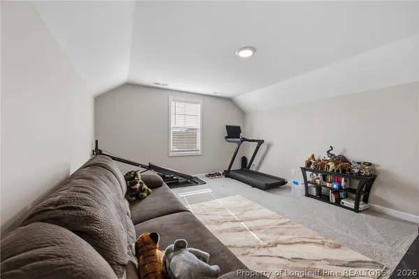 a bed sitting in a bedroom next to a window and a couch