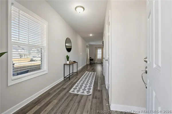 a view of a hallway with wooden floor and staircase