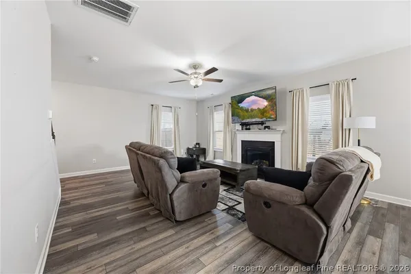 a living room with furniture a fireplace and a flat screen tv