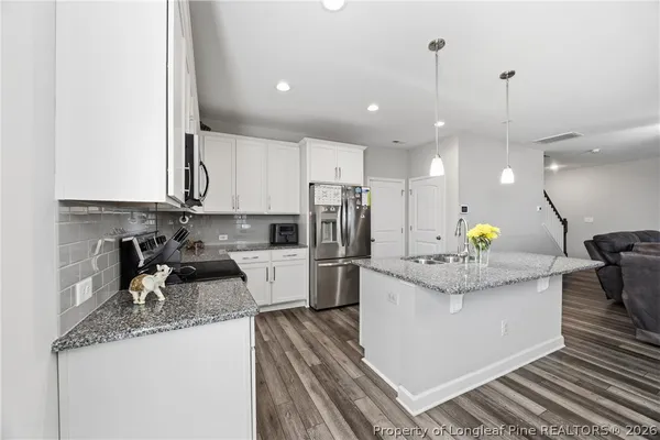 a kitchen with stainless steel appliances granite countertop sink stove and refrigerator