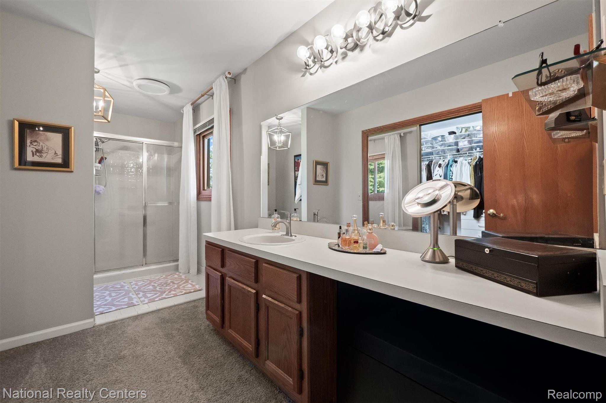 2203 Rochelle Park Drive Rochester, MI 48309 - Photo 26 of 43 Bathroom vanity featuring dual mirrors, a wood-finish cabinet, and light-tone countertop