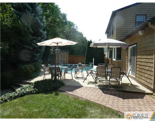 64 Ridge Road Edison, NJ 08817 - Photo 20 of 22 a view of a patio with table and chairs under an umbrella