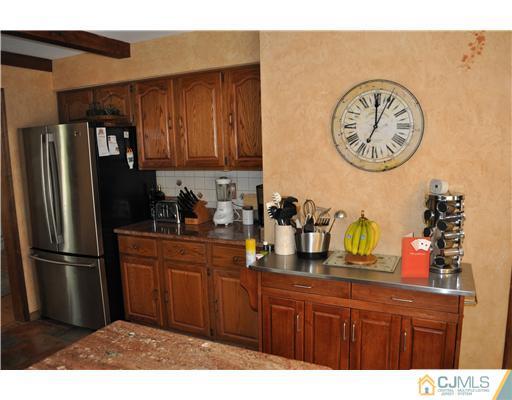 64 Ridge Road Edison, NJ 08817 - Photo 7 of 22 a kitchen with a refrigerator and cabinets