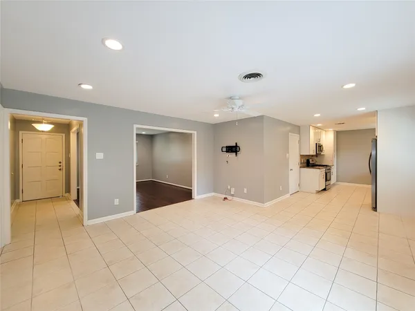 a view of a livingroom with kitchen and entryway