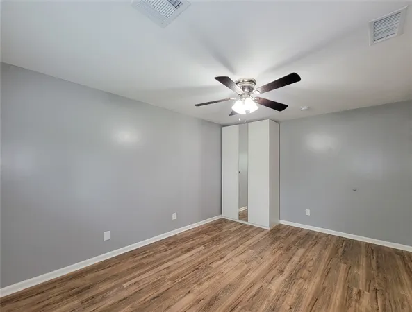 a view of an empty room with a chandelier fan
