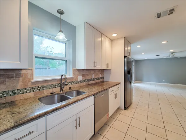a kitchen with a sink window and cabinets