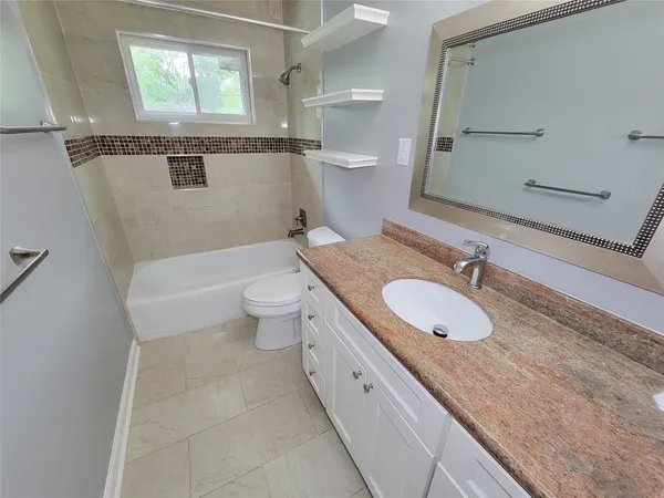 a bathroom with a granite countertop double vanity sink and a mirror