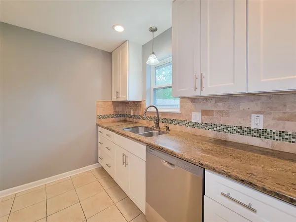a kitchen with a sink window and cabinets
