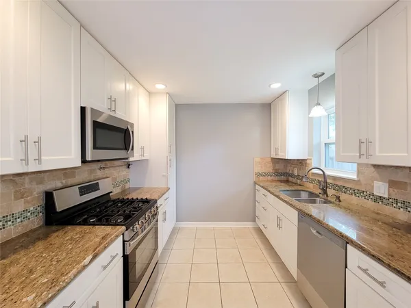 a large kitchen with a stove and a sink