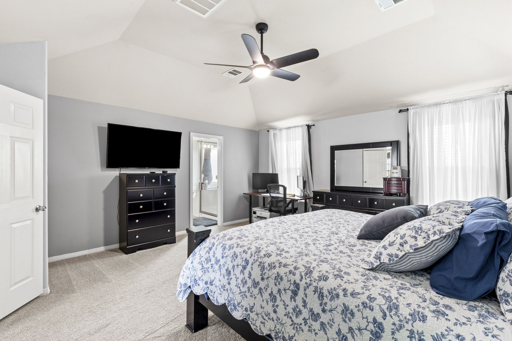 227 Sandstone Trail Buda, TX 78610 - Photo 12 of 33 Spacious bedroom featuring light grey walls, vaulted ceiling, and light-toned carpet flooring