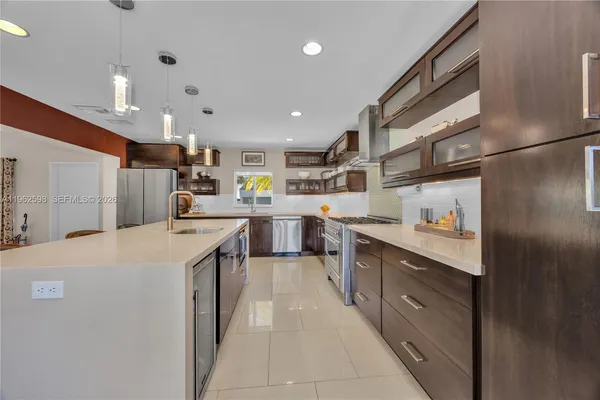 a large kitchen with stainless steel appliances lots of counter space and a sink
