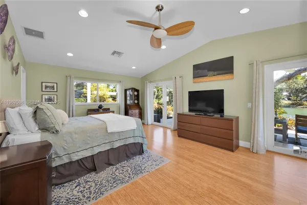 a bedroom with a large bed a flat screen tv and a couch