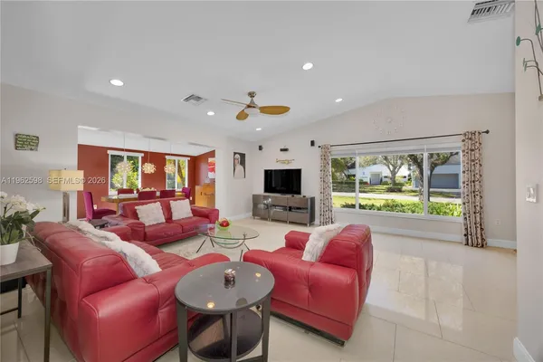a living room with furniture a flat screen tv and a large window