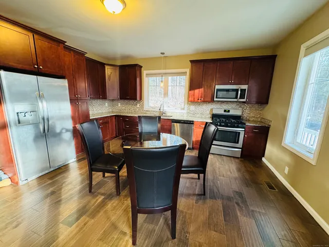 a kitchen with stainless steel appliances wooden floors and wooden cabinets
