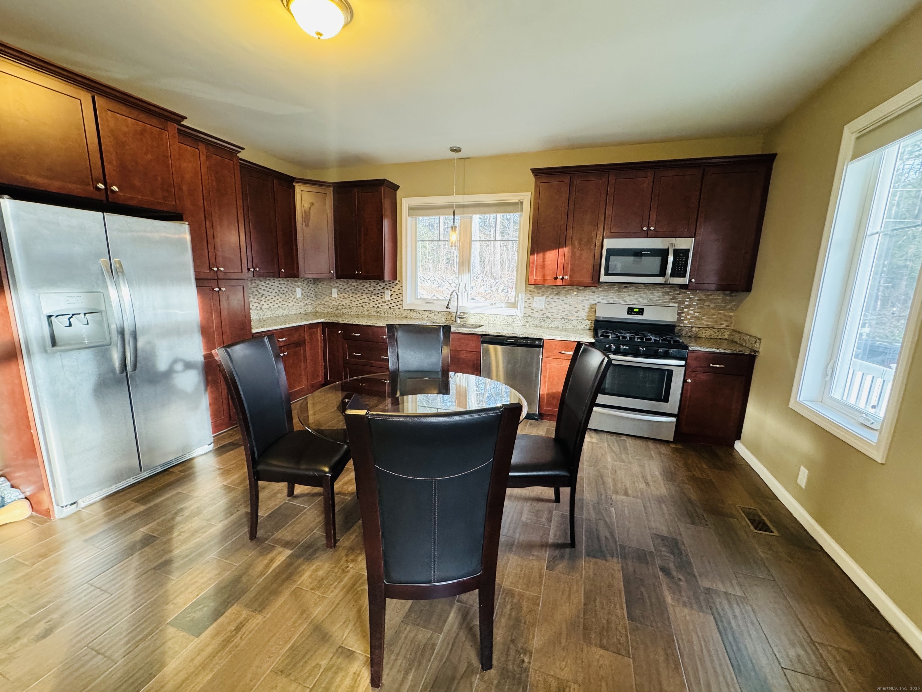123 Ashford Road, Unit 1 Eastford, CT 06242 - Photo 8 of 24 a kitchen with stainless steel appliances wooden floors and wooden cabinets