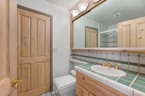 a bathroom with a granite countertop sink and a mirror with toilet