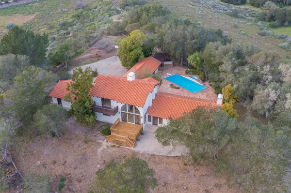 an aerial view of a house with a yard and trees