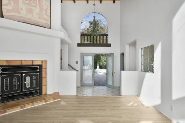 a view of a livingroom with a fireplace windows and a chandelier