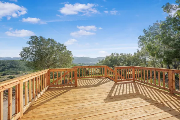 a view of balcony with wooden floor and fence
