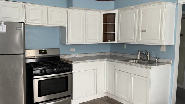 a kitchen with granite countertop white cabinets and stainless steel appliances