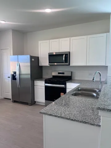 a kitchen with granite countertop a refrigerator and a sink