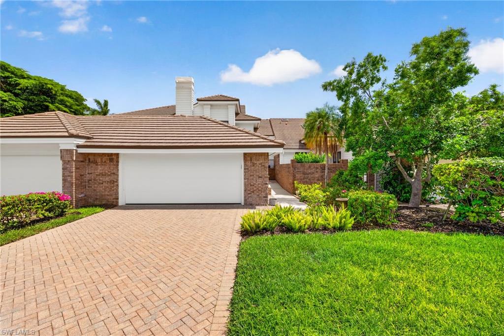 4030 Crayton Road, Unit C2 Naples, FL 34103 - Photo 2 of 32 a front view of a house with a garden and plants