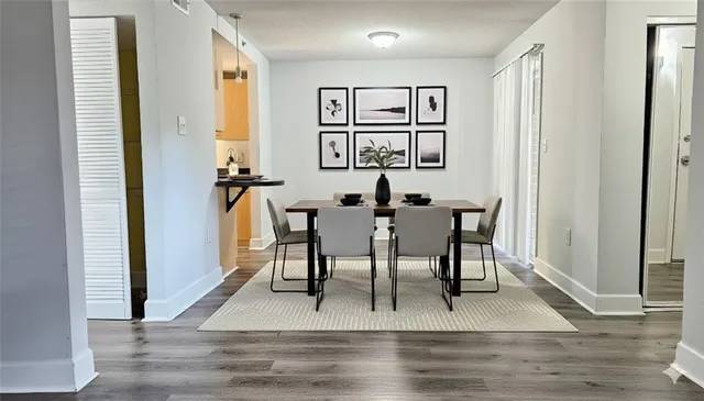 a view of a a dining room with furniture window and wooden floor