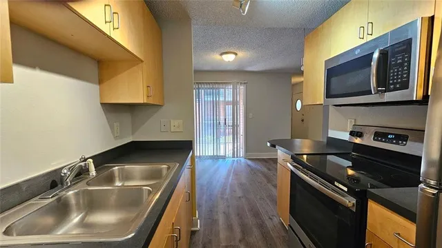 a kitchen with a sink stove and microwave