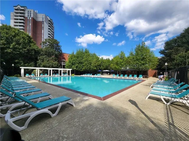 a view of a swimming pool with a bench in a backyard