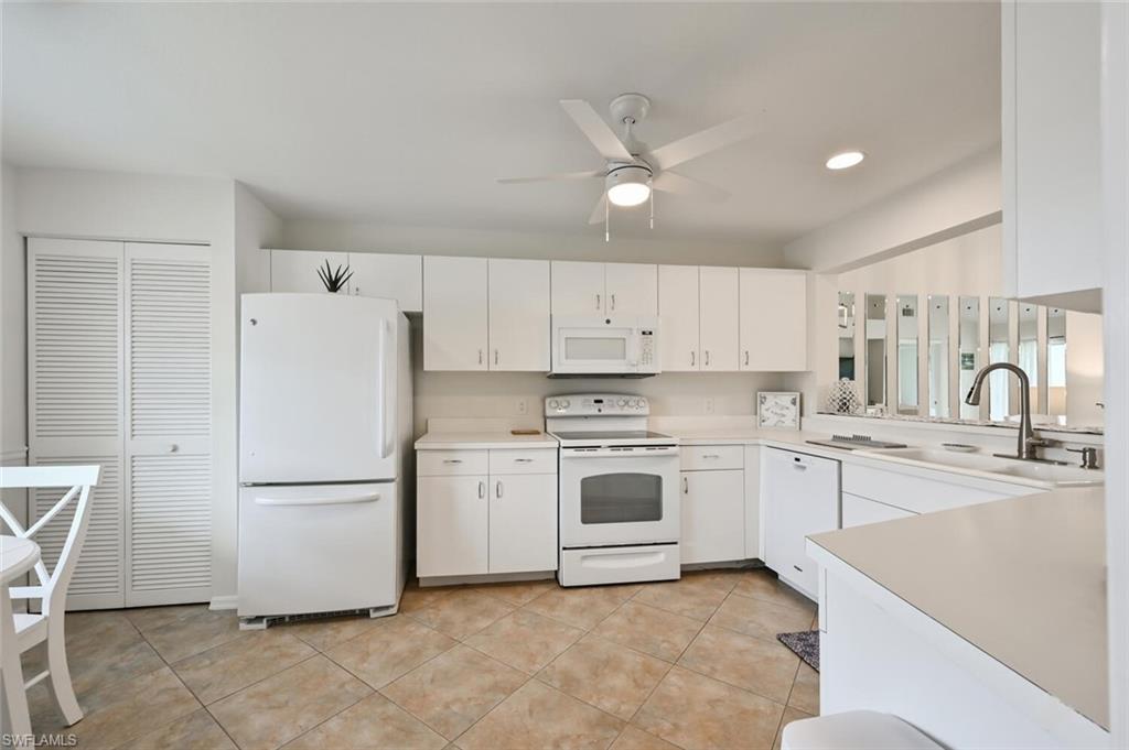 515 Gabriel Circle, Unit 1910 Naples, FL 34104 - Photo 11 of 29 a kitchen with a refrigerator and a sink