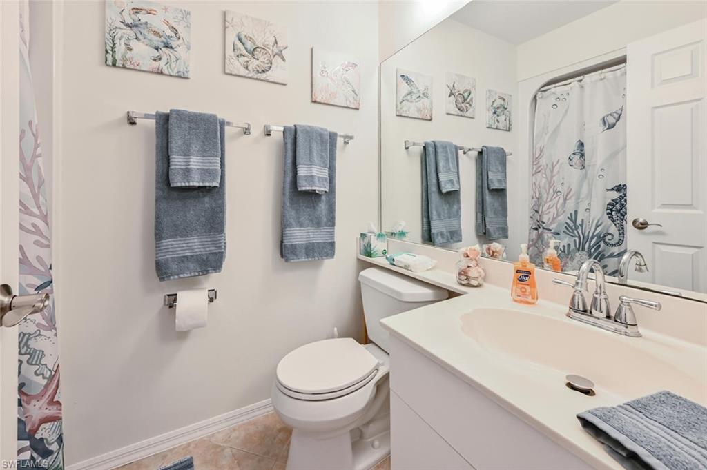 515 Gabriel Circle, Unit 1910 Naples, FL 34104 - Photo 15 of 29 a bathroom with a sink vanity mirror and toilet