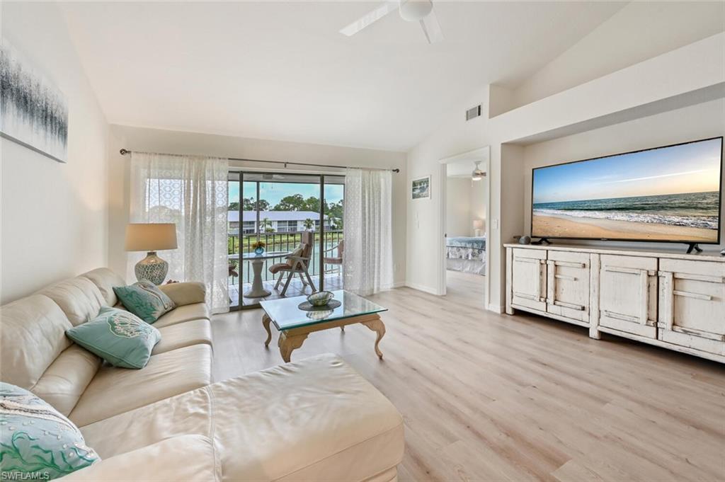 515 Gabriel Circle, Unit 1910 Naples, FL 34104 - Photo 2 of 29 a living room with furniture and large windows