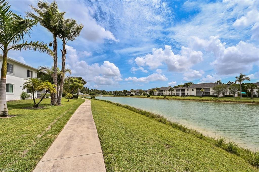 515 Gabriel Circle, Unit 1910 Naples, FL 34104 - Photo 21 of 29 a view of a lake with a yard