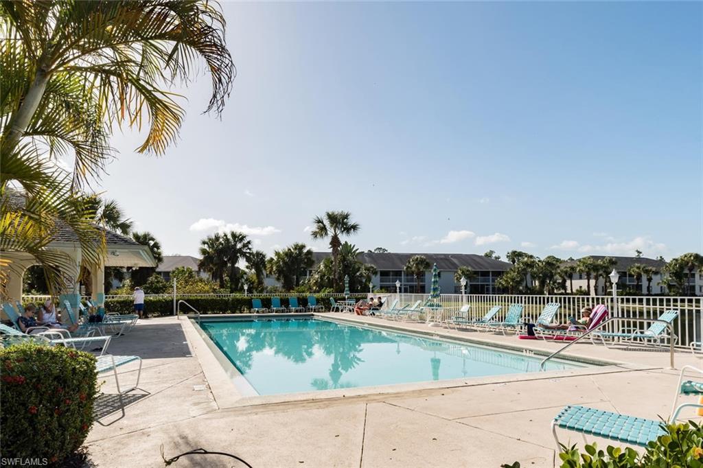 515 Gabriel Circle, Unit 1910 Naples, FL 34104 - Photo 25 of 29 a view of swimming pool with a table and chairs