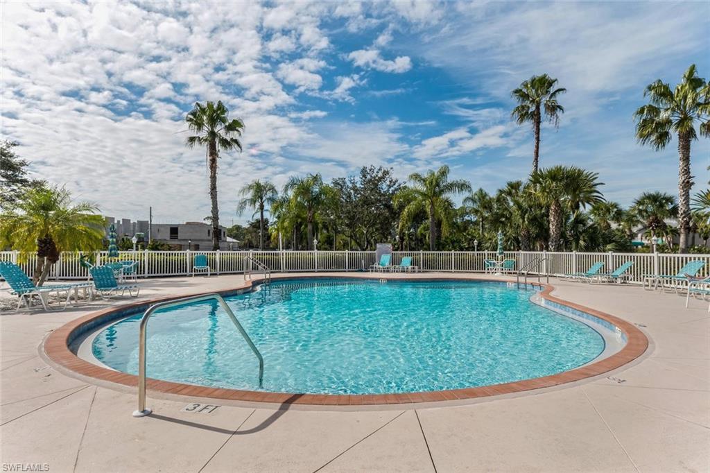 515 Gabriel Circle, Unit 1910 Naples, FL 34104 - Photo 27 of 29 a view of a swimming pool with a lawn chairs